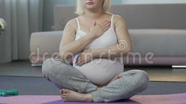 未来的母亲<strong>坐</strong>在地板上，揉着肚子，<strong>盘腿</strong>姿势，<strong>瑜伽</strong>